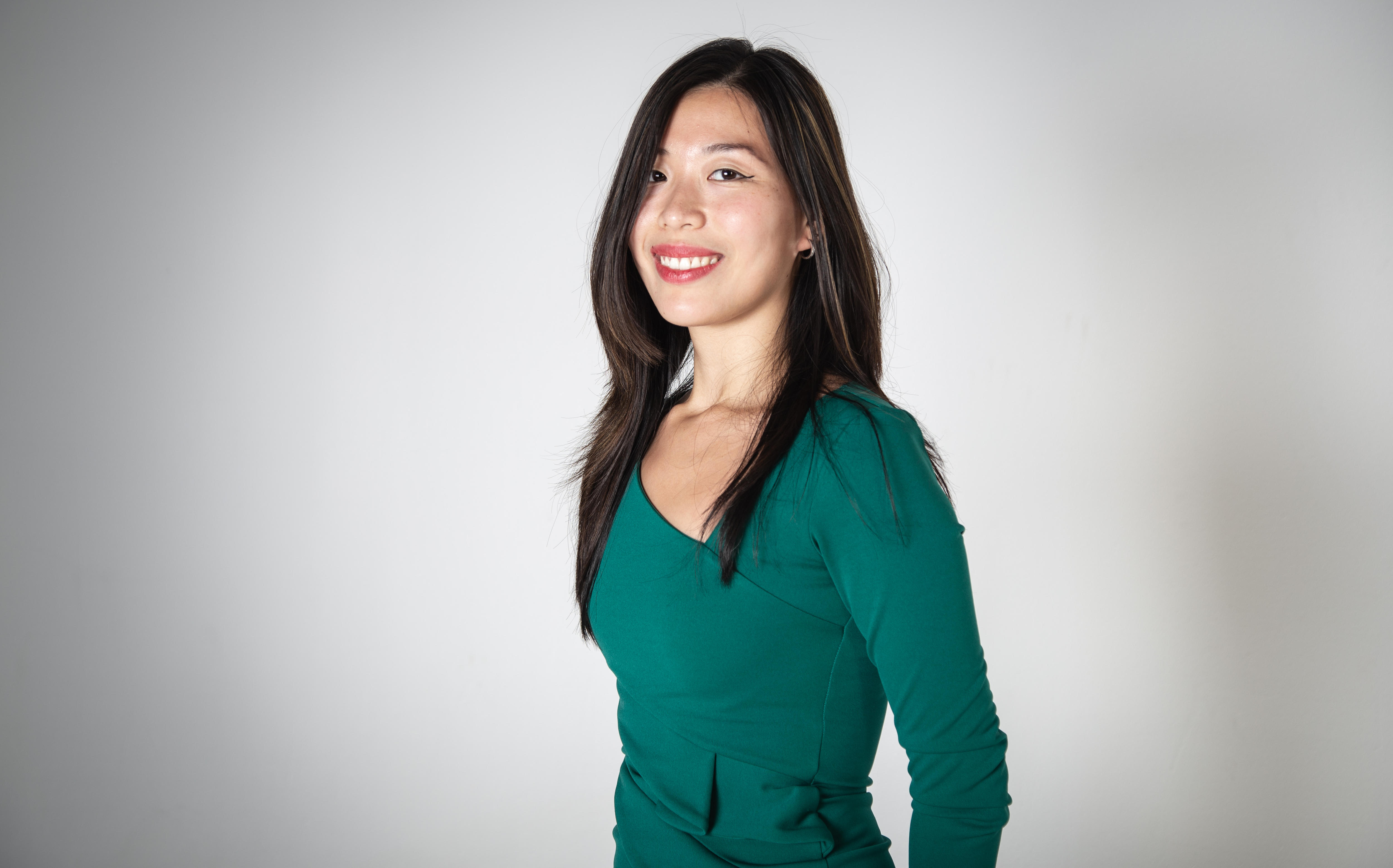 a woman smiling in front of a white background